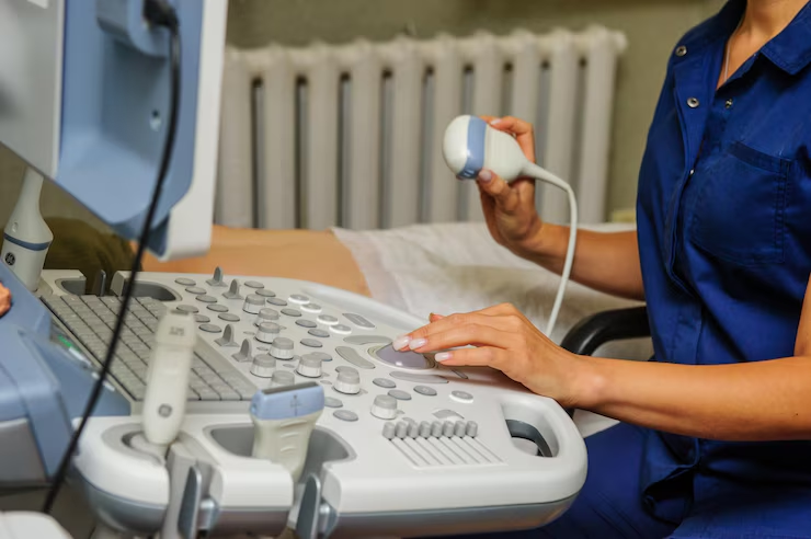 A medical professional performs an ultrasound examination using a sonography machine.