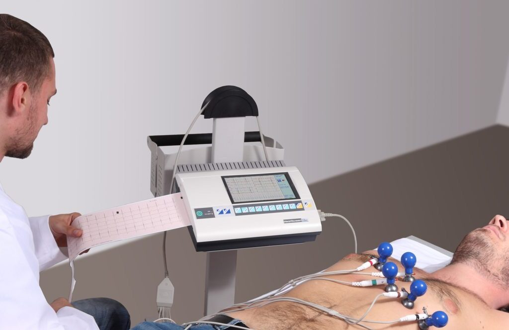 A medical professional monitors a patient undergoing an electrocardiogram (ECG) test.