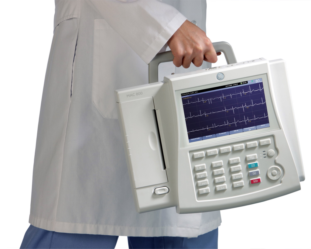 A healthcare professional holds a portable electrocardiograph (ECG) machine.